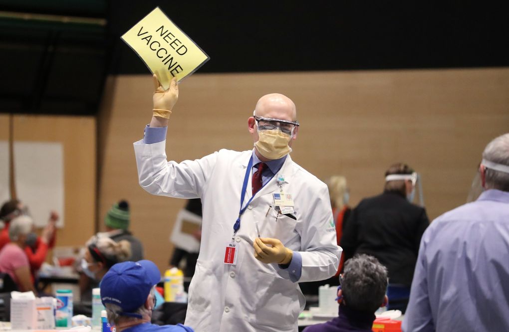 Dr. John Corman signals for more Pfizer vaccine as Amazon partners with Virginia Mason to create a pop-up COVID-19 vaccine clinic in Amazon’s Seventh Avenue meeting center in Seattle on Sunday. (Ken Lambert / The Seattle Times)