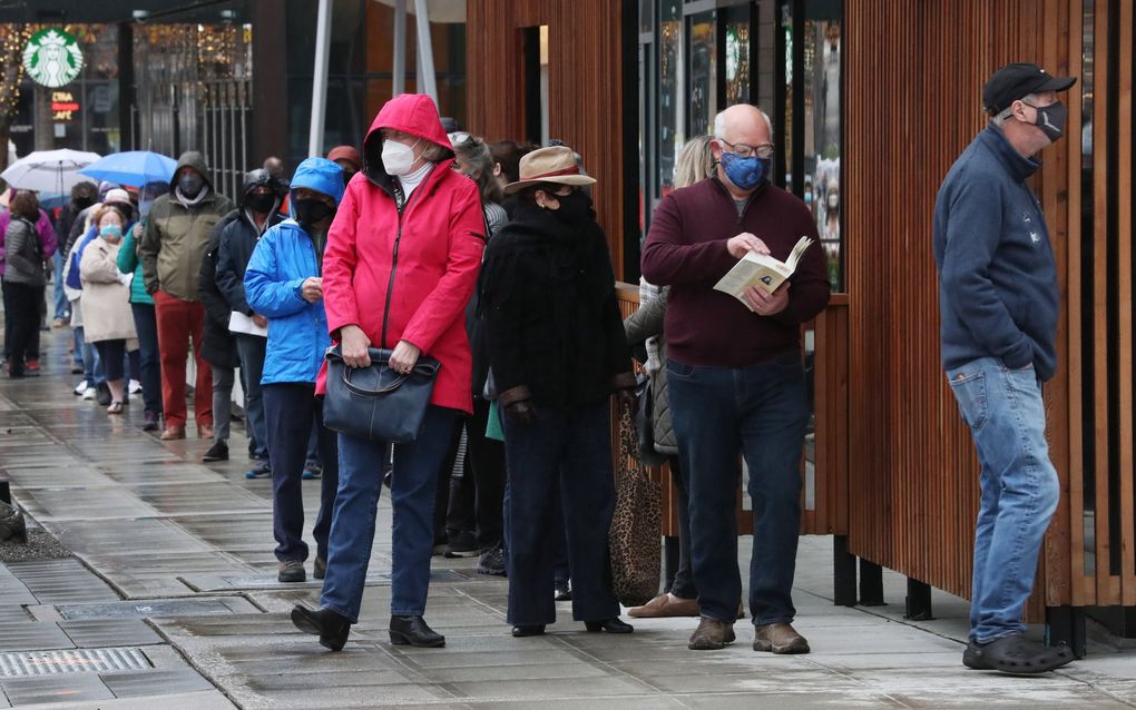 A line for coronavirus vaccines snakes around the corner at the pop-up clinic put on by Amazon and Virginia Mason on Sunday afternoon. (Ken Lambert / The Seattle Times)