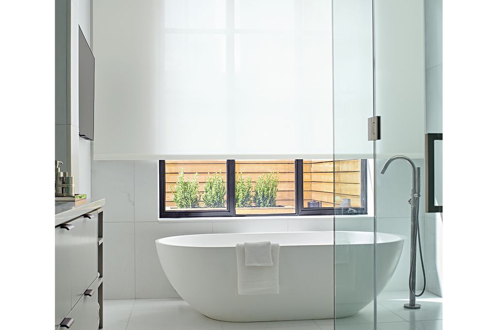 Roller shades are a sleek choice for a minimally furnished space. They are also easy to raise when you want to enjoy the view. (Courtesy of the Shade Store)