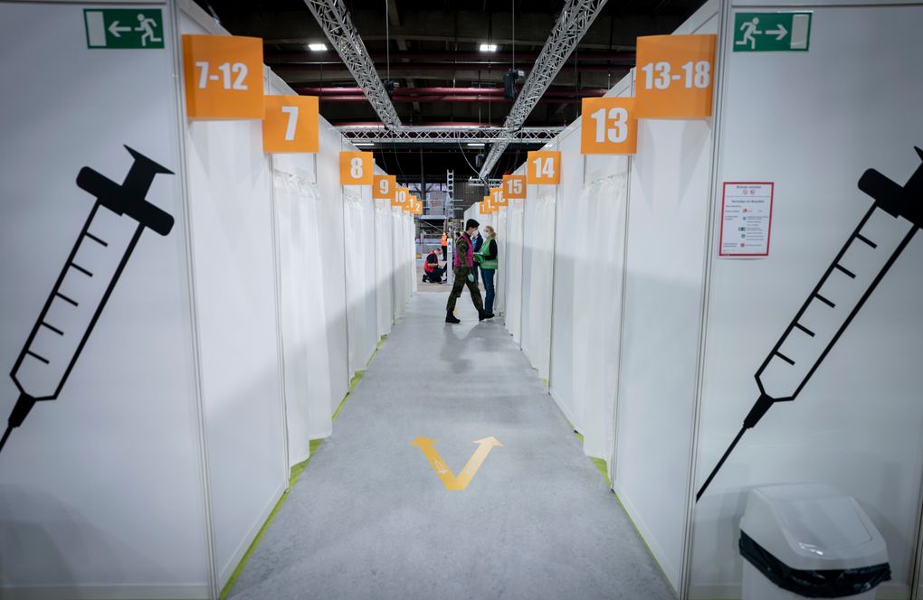 Volunteers stand inside the new open Erika-Hess-Eisstadion vaccine center in Berlin, Germany, Thursday, Jan. 14, 2021. (Kay Nietfeld/Pool vis AP)