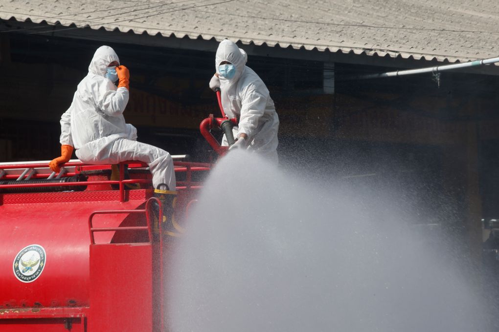Workers spray disinfectant as a precaution against the coronavirus at a shrimp market in Samut Sakhon, Thailand, Monday, Jan. 25, 2021. Thailand on Monday registered a new daily high of over 900 confirmed new cases of the coronavirus at the province near the capital Bangkok, where a major outbreak occurred in December. (AP Photo)