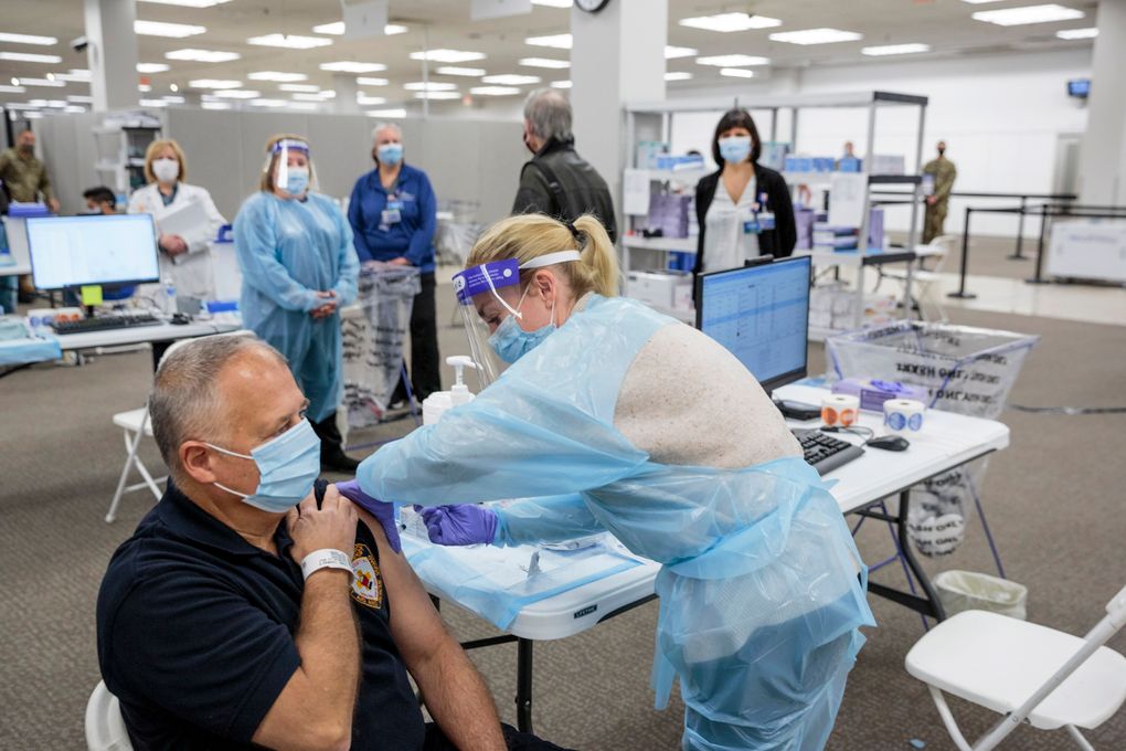 Sergeant Brian Patrick McKnerney, of the New Jersey State Police, receives a COVID-19 vaccination at the Morris County, vaccination site, in Rockaway, NJ, Friday, Jan. 8, 2021. Gov. Phil Murphy toured what’s being called a vaccine megasite at a former Sears store in Morris County on Friday where health officials hope to vaccinate more than 2,000 people per day in coming weeks and months. (Sarah Blesener/The New York Times via AP, Pool)