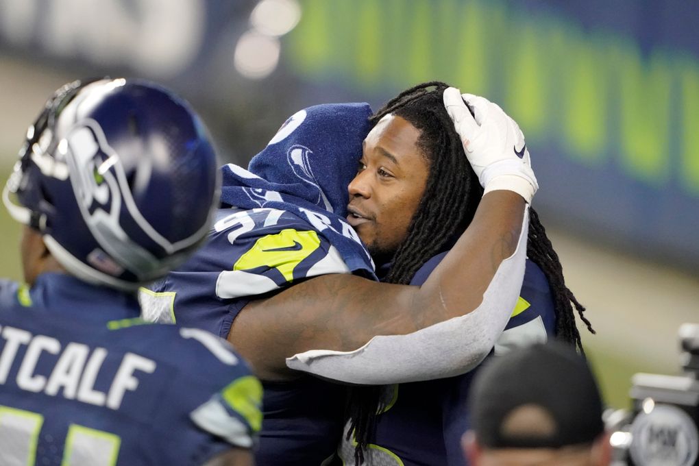 Seattle Seahawks’ Shaquill Griffin, right, embraces teammate Poona Ford after the Seahawks’ loss to the Rams team lost to the Los Angeles Rams in an NFL wild-card playoff football game, Saturday, Jan. 9, 2021, in Seattle. (AP Photo/Ted S. Warren)
