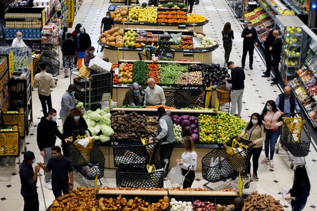 People shop at a supermarket as they stock up on provisions, in Beirut, Lebanon, Monday, Jan. 11, 2021. Panic buyers swarmed supermarkets after reports the government planned to also order them shut in the tightened lockdown. Long lines formed outside chain supermarkets, sparking fear the crowds could further spread the virus. (AP Photo/Bilal Hussein)