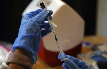 A syringe is filled with a dose of the Pfizer-BioNTech COVID-19 vaccine at a vaccine center in Rohnert Park, Calif., Jan. 27, 2021. People who have already been sick with COVID should still get vaccinated for maximum protection, experts say, but the first dose may come with intense side effects. (Jim Wilson/The New York Times) XNYT107 XNYT107