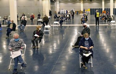 People that received a COVID-19 vaccine socially distance as they wait the required fifteen minutes to monitor for adverse reactions after getting the shot at the Dallas County mass vaccination site at Fair Park Wednesday, Jan. 20, 2021, in Dallas. (AP Photo/LM Otero) TXMO110 TXMO110