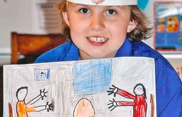 The author’s son, 9-years-old, holds a drawing based on a Japanese folk tale, of a couple eagerly waiting for a giant peach to give birth to their son.