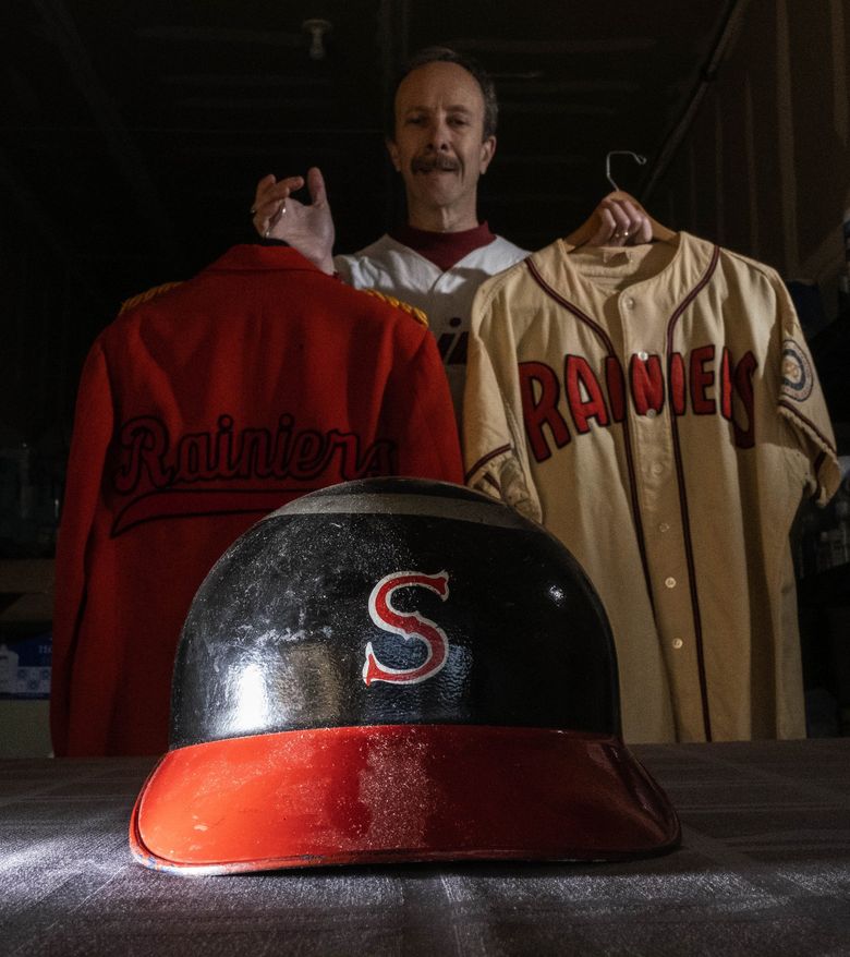 Charles Kapner’s collection of Seattle baseball memorabilia is a trip through the history of baseball in Seattle. Kapner, who brought the items out of a safety deposit box for The Times to view, holds a 1951 Rogers Hornsby jersey and a Rainiers ticket-taker’s jacket. Hornsby, a Hall of Famer and one of the best hitters in Major League history, managed the Rainiers to the pennant in his only year with the team. (Dean Rutz / The Seattle Times)