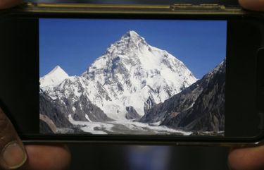 A photo of K2, the world’s second-highest mountain, is displayed on a cell phone in Islamabad, Pakistan, Tuesday, Feb. 9, 2021. Families of the three mountaineers who went missing in Pakistan last week while attempting to scale K2 are growing more desperate on Tuesday, a day after bad weather halted the search for the climbers. (AP Photo/Anjum Naveed) ANJ102 ANJ102