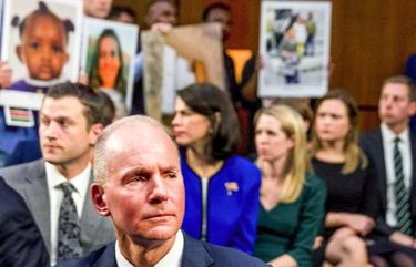 Boeing President and Chief Executive Officer Dennis Muilenburg turns back to face the Senate Committee while family members hold up photographs of those killed in the Ethiopian Airlines Flight 302 and Lion Air Flight 610 crashes during a Senate Committee on Commerce, Science, and Transportation hearing on Capitol Hill in 2019. NYBZ170