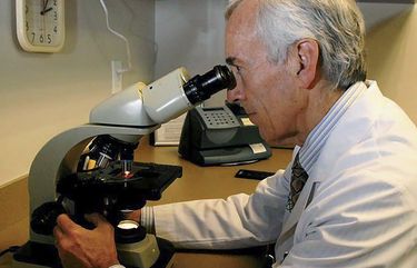 In this undated photo provided by Atlanta Allergy & Asthma, Dr. Stanley Fineman looks through a microscope at Atlanta Allergy & Asthma Center in Atlanta to examine the pollen. When Fineman started 40 years ago as an allergist in Atlanta, he told patients they should start taking their medications and prepare for the onslaught of pollen season around St. Patrickâ€™s Day. Now he tells them to start around St. Valentineâ€™s Day. (Robin B. Panethere /Atlanta Allergy & Asthma via AP) NYCD801 NYCD801