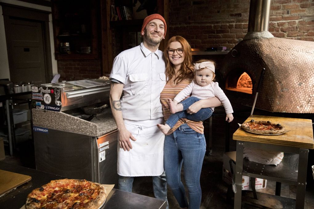 Ian and Ashley Galbraith pose with their daughter, Cleo, at their restaurant, The Carlson Block, in Wilkeson, Pierce County. (Amanda Snyder / The Seattle Times)