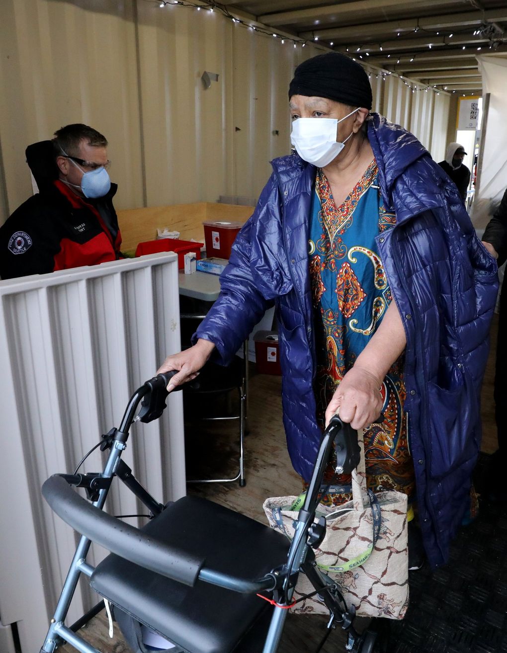 Rosetta DeCuir leaves after receiving her first COVID-19 vaccine dose from Seattle firefighter Garth Stroyan at the Southwest Athletic Complex on Thursday.(Alan Berner / The Seattle Times)