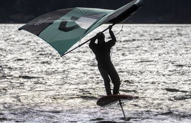 Friday, Feb. 19, 2021 LO A foilboard pilot turns his wing as he cuts back into a blustery wind off of Magnuson Park in Seattle. 216444