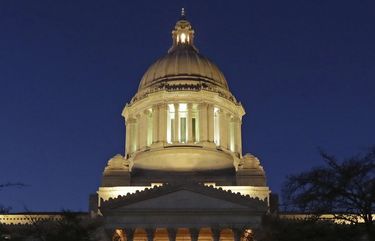 FILE – In this Dec. 4, 2018 file photo, pedestrians make their way  toward the Legislative Building at dusk at the Capitol in Olympia, Wash. The Washington Supreme Court ruled Thursday, Dec. 19, 2019 that the Public Records Act fully applies to state lawmakers. The justices heard oral arguments in June on the appeal of a case that was sparked by a September 2017 lawsuit filed by a media coalition, led by The Associated Press, which was seeking sexual harassment reports, calendar entries and other documents from legislators. The justices found for the media coalition in a 7 to 2 decision. (AP Photo/Ted S. Warren, File)