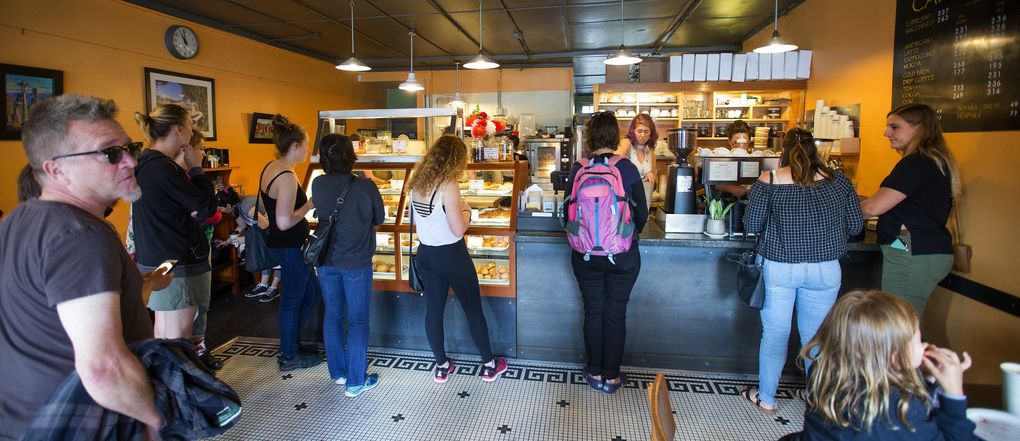In pre-pandemic times, you could run into someone new and strike up a conversation while waiting in line for a latte at your local coffee shop — in this case, a busy Cafe Besalu in Ballard in August 2017. But these sorts of chance occurrences have dwindled to nothing during the COVID-19 pandemic. (Mike Siegel / The Seattle Times)