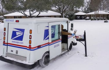 Letter carrier Angel Garcia delivers mail to a snow covered neighborhood after a second winter storm brought more snow and continued freezing temperatures to North Texas on Wednesday, Feb. 17, 2021, in Richardson, Texas. “We’re going slow, but we are getting it delivered,” Garcia said of USPS mail deliveries. (Smiley N. Pool/The Dallas Morning News via AP) TXDAM802 TXDAM802