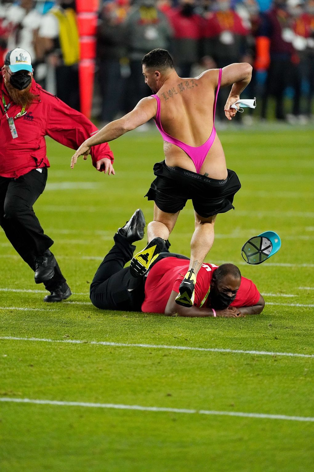 Security tries to grab a fan on the field during the second half of the Super Bowl between the Tampa Bay Buccaneers and the Kansas City Chiefs on Sunday. (Doug Benc / The Associated Press)