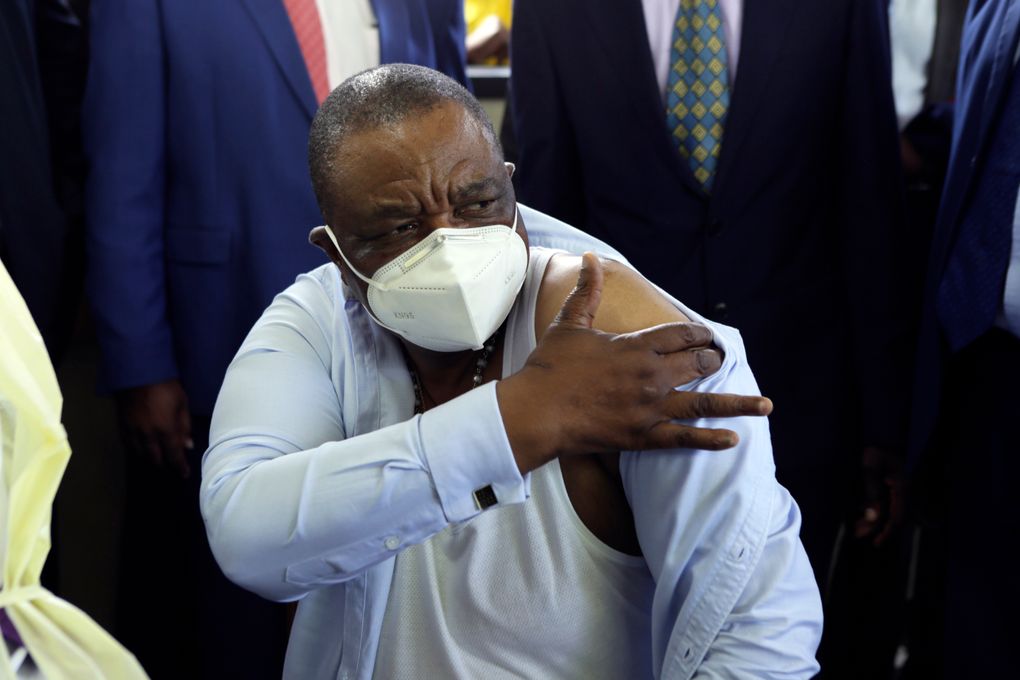 Zimbabwean Deputy President Constatino Chiwenga, reacts after getting a shot of China’s Sinopharm vaccine, at local hospital in Harare, Thursday, Feb, 18, 2021. Chiwenga become the first person in the country to receive the jab, marking the first phase of the country’s vaccination campaign.(AP Photo/Tsvangirayi Mukwazhi)
