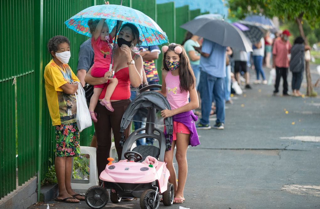 People wait in line outside a public school to get a shot of China’s Sinovac CoronaVac vaccine in Serrana, Sao Paulo state, Brazil, Wednesday, Feb. 17, 2021. Brazil’s Butantan Institute started a mass vaccination on Wednesday of the city’s entire adult population, about 30,000 people, to test the virus’ behavior in response to the vaccine. (AP Photo/Andre Penner)