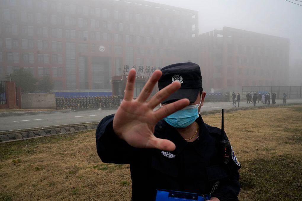 FILE – In this Feb. 3, 2021, file photo, a security person moves journalists away from the Wuhan Institute of Virology after a World Health Organization team arrived for a field visit in Wuhan in China’s Hubei province. (AP Photo/Ng Han Guan, File)