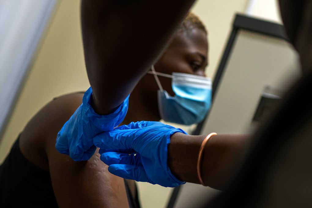 FILE – In this Nov. 30, 2020 file photo, Thabisle khlatshwayo, who received her first shot for a COVID-19 vaccine trial, receives her second AstraZeneca shot at a vaccine trial facility set at Soweto’s Chris Sani Baragwanath Hospital outside Johannesburg, South Africa. South Africa suspended on Sunday Feb. 7, 2021 plans to inoculate its front-line health care workers with the AstraZeneca vaccine after a small clinical trial suggested that it isn’t effective in preventing mild to moderate illness from the variant dominant in the country. (AP Photo/Jerome Delay, File)