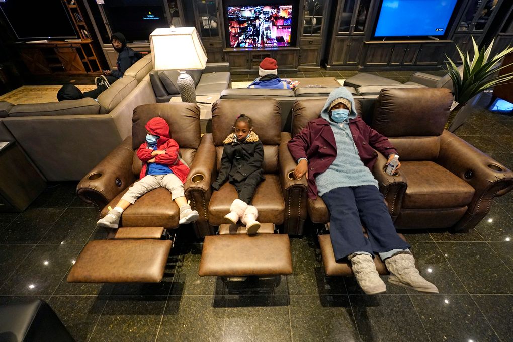 FILE – In this Feb. 17, 2021, file photo, Joecyah Heath, left, Morning Day, center, and Jenesis Heath rest in recliners at a Gallery Furniture store which opened as a shelter in Houston. Making decisions about risks — large or small — in the pandemic era is fraught enough. But the storms and outages ravaging Texas and other states have added a whole new layer to the process. (AP Photo/David J. Phillip, File)