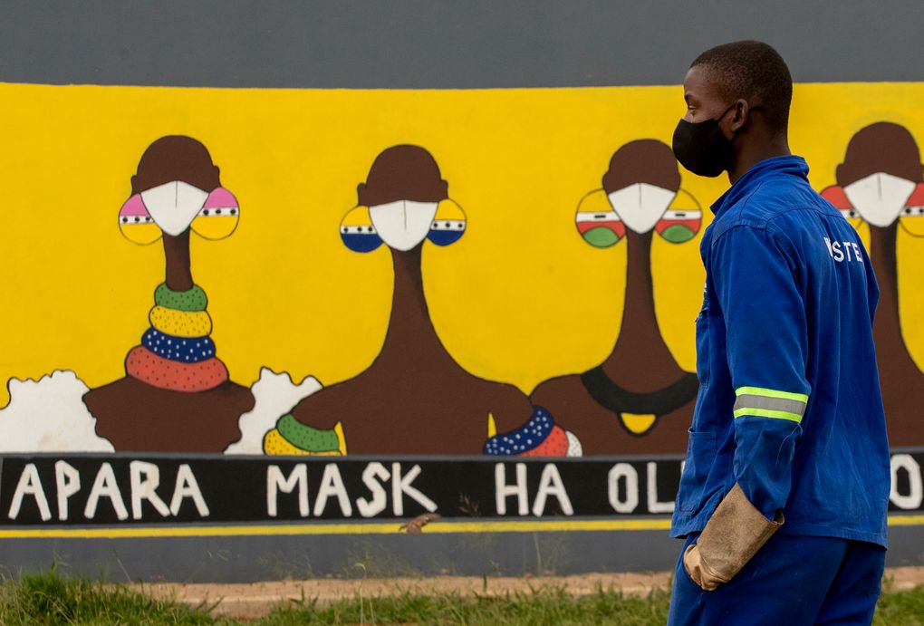 A man walks past a coronavirus-themed mural promoting the use of face mask in public place, in Sebokeng, Vereeniging, South Africa, Thursday, Jan. 28, 2021. (AP Photo/Themba Hadebe)