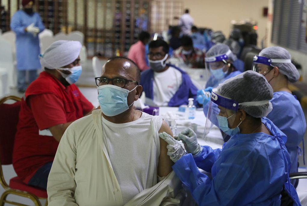 A man receives a Sinopharm COVID-19 vaccine from a medical staffer at the Guru Nanak Darbar Sikh Temple, in Dubai, United Arab Emirates, Monday, Feb. 8, 2021. With the coronavirus pandemic surging to new heights in the UAE, the Sikhs of Dubai have traded their traditional fare of free meals for free COVID-19 vaccines. The city’s Sikh temple is administering 5,000 shots made by state-backed Chinese firm Sinopharm to those who may otherwise struggle to be vaccinated. (AP Photo/Kamran Jebreili)