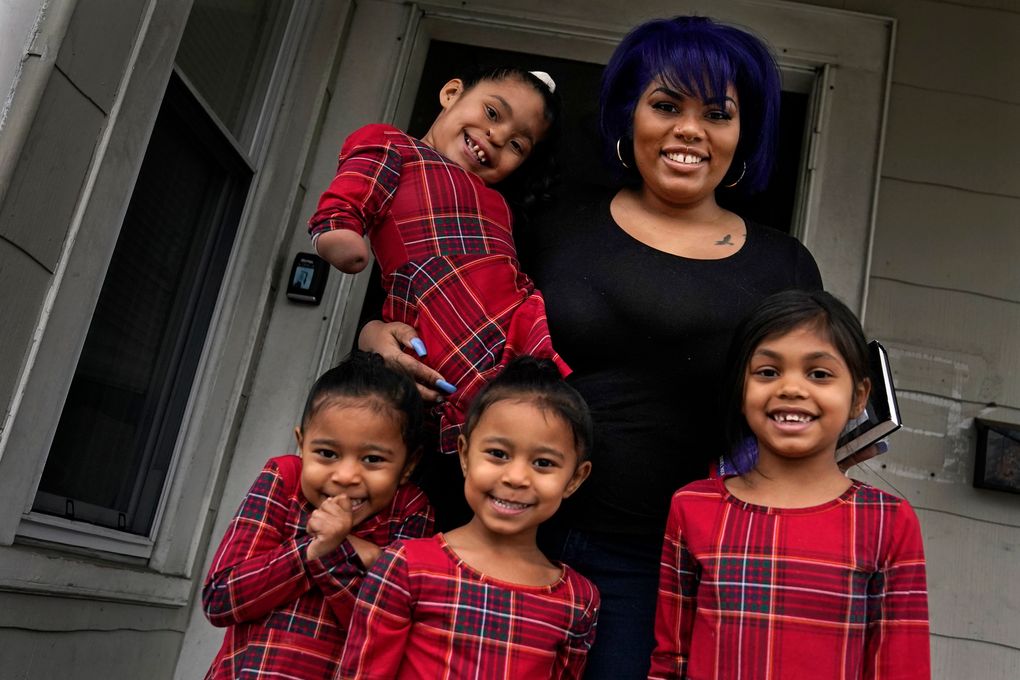Dinora Torres, a MassBay Community College student, poses with her four daughters at their home in Milford, Massachusetts. At the college, applications for meal assistance scholarships have increased 80% since last year. Among the recipients is Torres, who said the program helped keep her enrolled. (Charles Krupa / Associated Press)