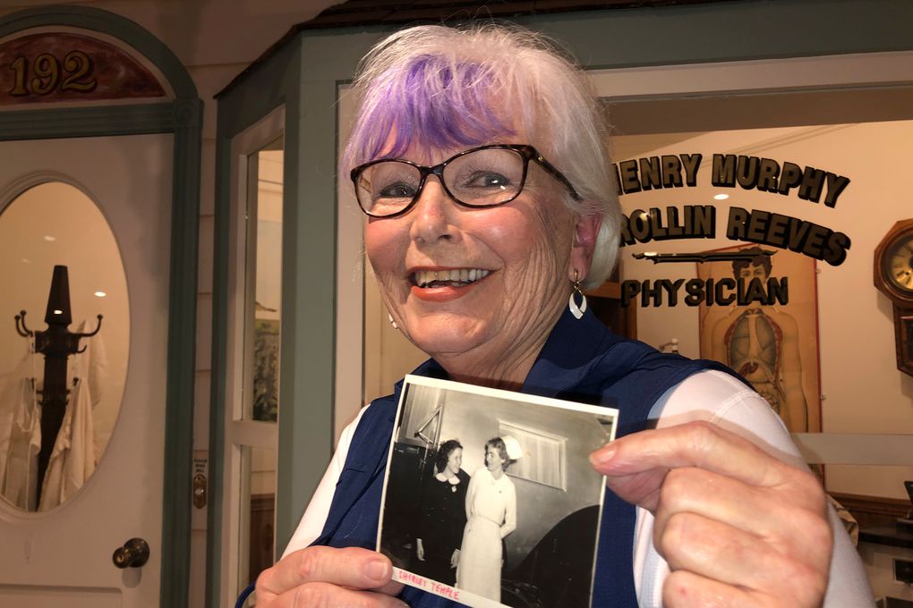 Nurse practitioner Sigrid Stokes, 76, holds a photograph of her mother talking to Shirley Temple, at the Salinas Valley Memorial Hospital in Salinas, Calif., Wednesday, Feb. 3, 2021. Stokes is following in her family’s footsteps during the pandemic. In 1918, Stokes’ mother Kristine Berg Mueller was a 14-year-old hospital volunteer in Norway during the Spanish Flu pandemic, putting her in regular contact with the deadly disease. (AP Photo/Haven Daley)