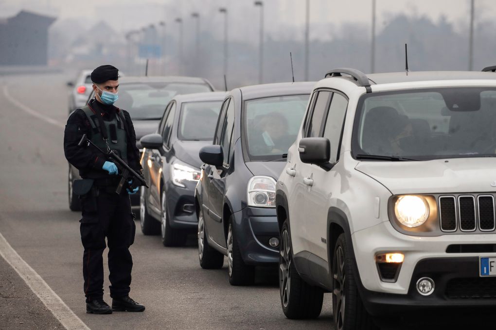 A Carabinieri officer patrols one of the main access road to Bollate, in the outskirt of Milan, Italy, Thursday, Feb. 18, 2021. Four cities in Lombardy region, including one in the province of Brescia, have been placed under the strictest “red zone” lockdown measures following spikes of infections traced to the highly contagious British variant. Other red zones have been imposed in cities in the central Italian regions of Umbria, Tuscany, Abruzzo and Lazio, sparking calls for another nationwide lockdown from hospital doctors who are once again seeing their ICU beds fill up. (AP Photo/Luca Bruno)