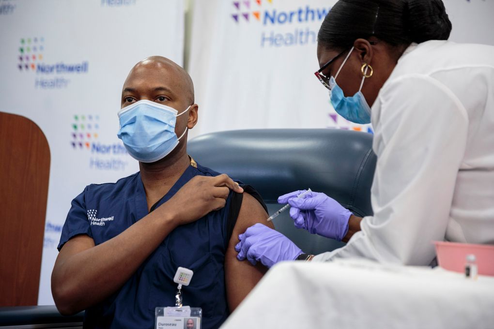 Michelle Chester administers a coronavirus vaccine to Dr. Yves Duroseau at Long Island Jewish Medical Center on Dec. 14. (photo for The Washington Post by Sarah Blesener).
