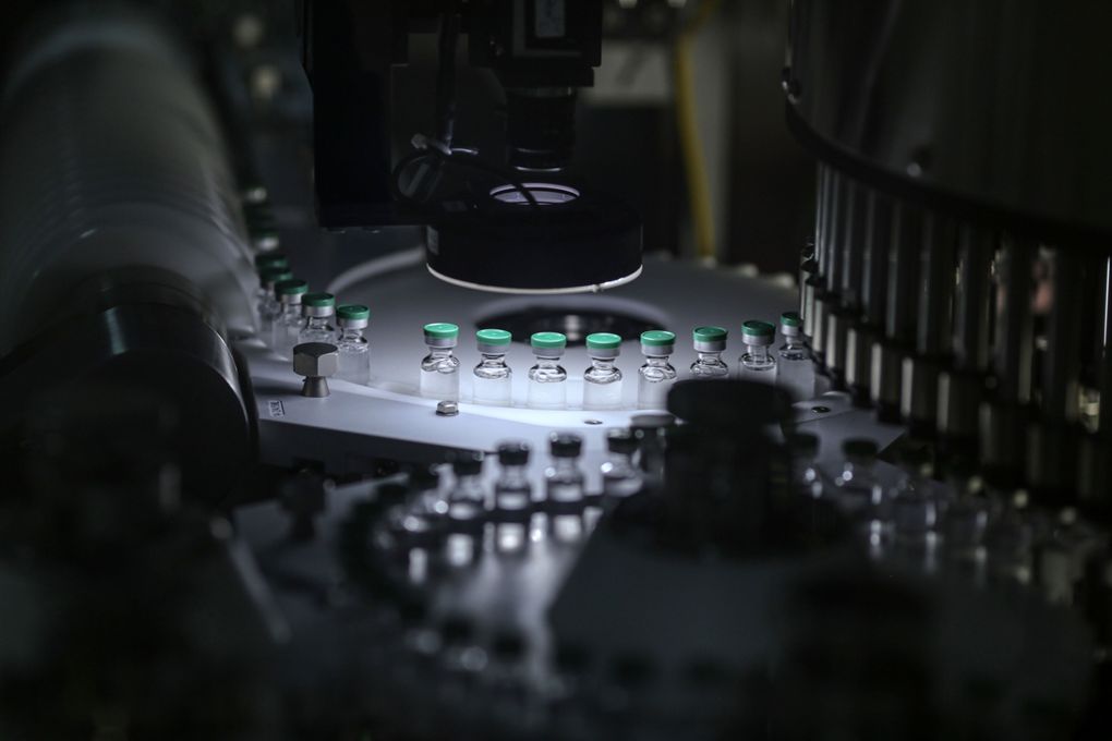 Vials of Covishield, the local name for the COVID-19 vaccine developed by AstraZeneca and the University of Oxford, move along a conveyor on the production line at the Serum Institute of India Ltd. Hadaspar plant in Pune, Maharashtra, India, on Jan. 22, 2021. (Bloomberg photo by Dhiraj Singh)