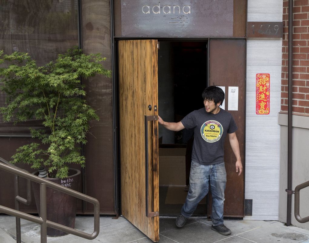 Shota Nakajima stands in Adana’s doorway as he and friends cleared out the space on Thursday, May 21, 2020. (Amanda Snyder / The Seattle Times)