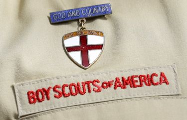 FILE – This Feb. 4, 2013, file photo, shows a detail of a Boy Scout uniform worn during a news conference in front of the Boy Scouts of America headquarters in Irving, Texas. On Monday, March 1, 2021, Boy Scouts of America submitted a bankruptcy reorganization plan that envisions continued operations of its local troops and national adventure camps but leaves many unanswered questions about resolving tens of thousands of sexual abuse claims by former Boy Scouts. NYPS210