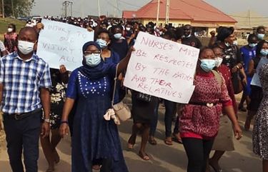 Nurses and supporters in Owo, Nigeria, participate in a march on Feb. 7, 2021, demanding the Federal Medical Centre in Owo provide security for its staff after two nurses were were attacked by the family of a deceased COVID-19 patient. A new report identified hundreds of threats or acts of violence against health care workers and facilities last year linked to fear or frustration around the coronavirus. (Tochukwu Q.O. via AP) NY224 NY224