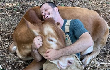 James Higgins cuddles with Tulsi. MUST CREDIT: Krishna Cow Sanctuary handout photo