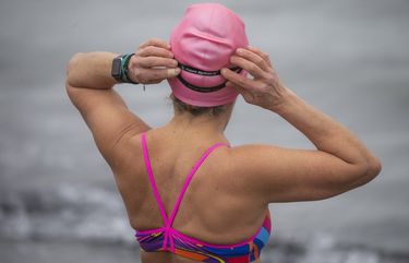 Stacey Sterling puts on her goggles for an open-water swim at Alki Beach in West Seattle Sunday February 14, 2021. 216352
