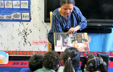 In this 2018 photo provided by Children’s Aid, Nina Crews, illustrator of “A Girl Like Me,” reads to children at an early childhood education center.  Crews said the work of independent publishers and grassroots organizers are vital in bringing more racial diversity into children’s books. (Adriana Alba/Childrenâ€™s Aid via AP) NYCD250 NYCD250