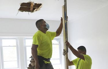 A construction crew working for Anton Downing, right, and his twin brother, Anthony, work on a bedroom of an apartment building that they are rehabbing on Chicago's South Side on July 11, 2020. (Abel Uribe/Chicago Tribune/TNS) 1728965