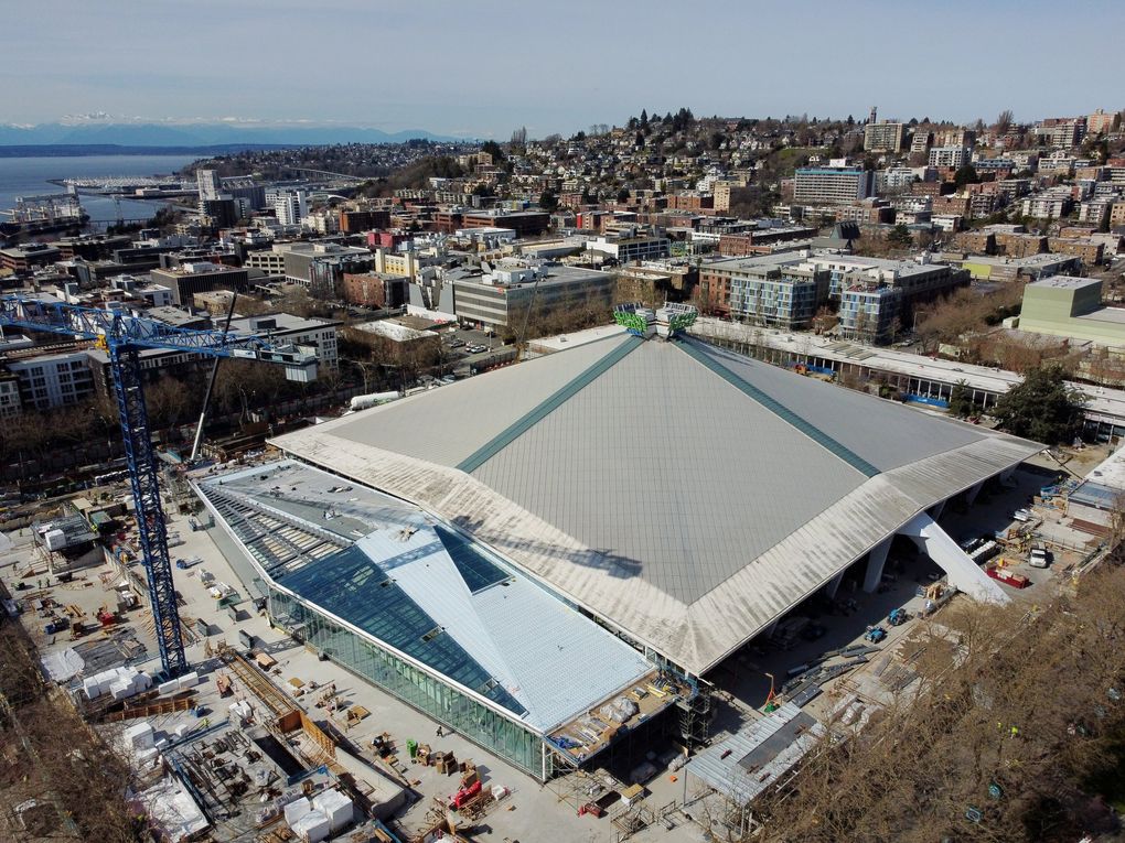 Concertgoers will enter the glassed Alaska Airlines Atrium, seen from the air at lower left, which borders the south side of Climate Pledge Arena as construction continues this month. (Ken Lambert / The Seattle Times)