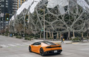FILE — A Lamborghini passes the Amazon campus in South Lake Union after most corporate employees were working from home in Seattle, March 5, 2020. Even as shared public spaces emptied out, the gap between the economically privileged and the precarious became impossible to ignore. XNYT20