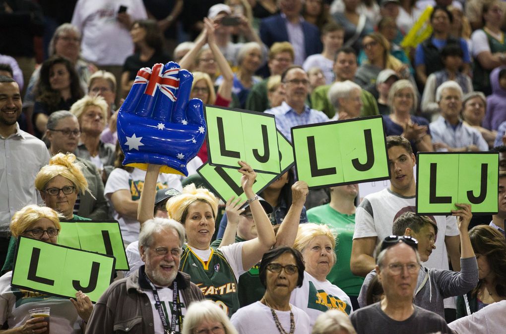 Fans wear blond wigs and hold “LJ” signs after the July 15, 2016, game between the Seattle Storm and Washington Mystics at KeyArena. Former Storm player Lauren Jackson, who was drafted in 2001 and spent her entire WNBA career in Seattle before injuries forced her to retire, was honored this night with the retirement of her jersey number, 15. Jackson helped the Storm win WNBA championships in 2004 and 2010, is a 7-time WNBA All-Star and three-time league MVP, among other accolades. (Lindsey Wasson / The Seattle Times)