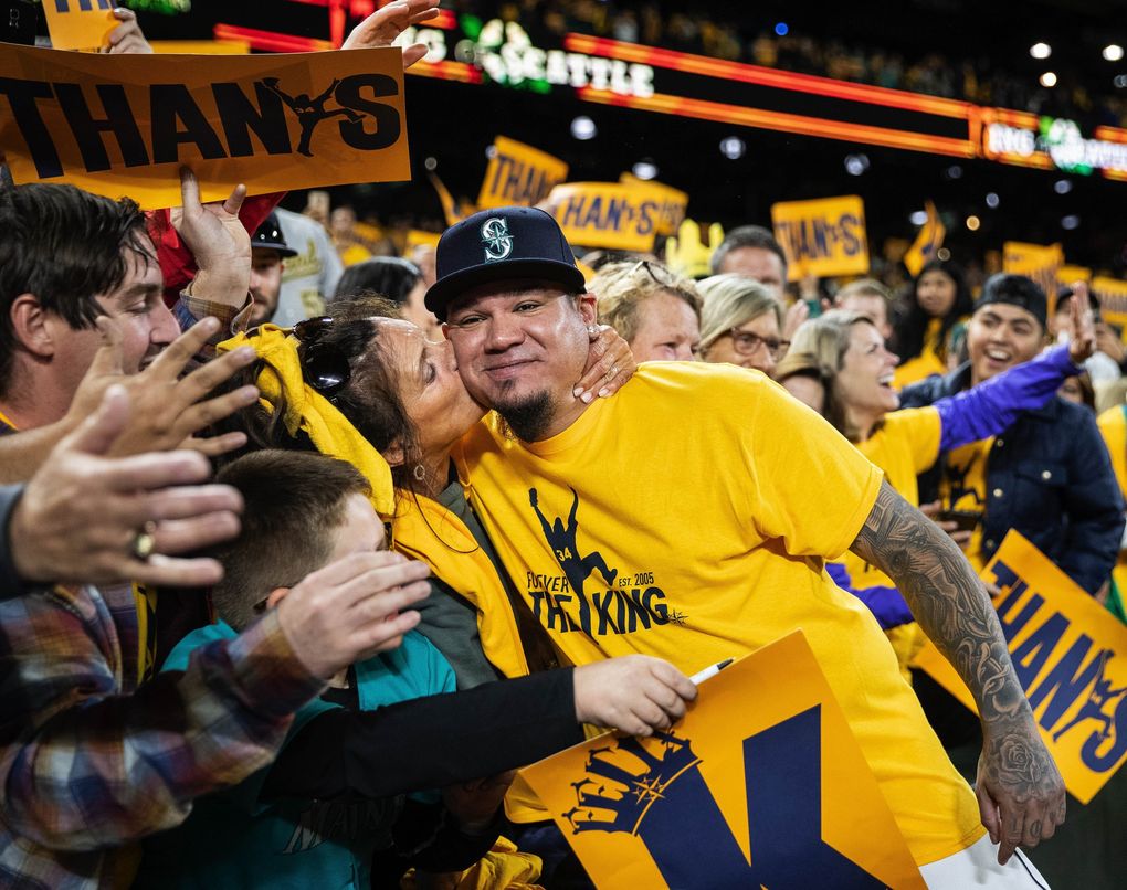 Marianne Mingione reaches out to grab Felix Hernandez, and plants a big kiss on his cheek as he greeted fans following the regular-season finale, Hernandez’s last in Seattle, in 2019. (Dean Rutz / The Seattle Times)