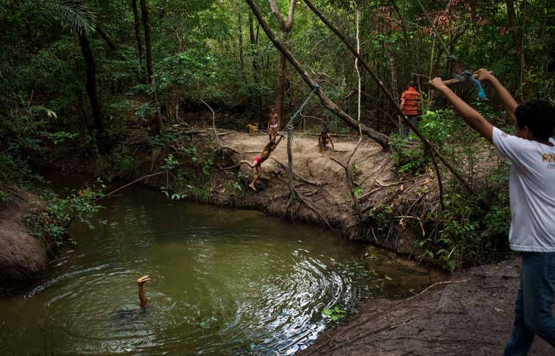 Daniel, son of Maria José Lima Pinheiro, his sister and cousins play in the Mamuna river in Alcântara, Maranhão, Brazil, on Feb. 10, 2021. MUST CREDIT: Photo for The Washington Post by Ingrid Barros