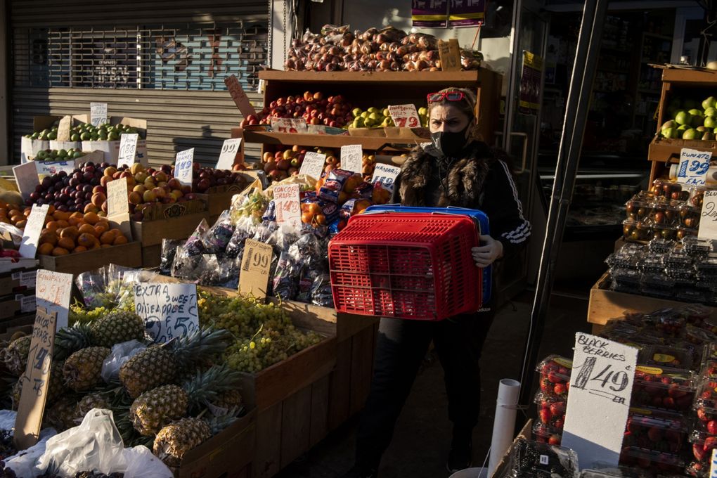 A woman carries shopping baskets at a grocery store in the Brooklyn borough of New York on Oct. 5, 2020. (Bloomberg photo by Mark Kauzlarich).