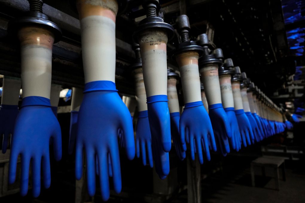 Latex gloves on hand-shaped molds move along an automated production line at a Top Glove factory in Setia Alam, Selangor, Malaysia, in 2020. (Bloomberg photo by Samsul said).