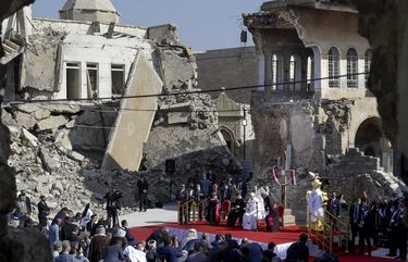 Pope Francis, surrounded by shells of destroyed churches, leads a prayer for the victims of war at Hosh al-Bieaa Church Square, in Mosul, Iraq, once the de-facto capital of IS, Sunday, March 7, 2021. The long 2014-2017 war to drive IS out left ransacked homes and charred or pulverized buildings around the north of Iraq, all sites Francis visited on Sunday. (AP Photo/Andrew Medichini) xds150 xds150