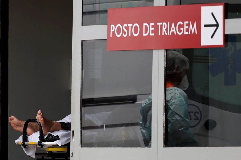 Healthcare workers take on a stretcher a patient suspected of having COVID-19 into the HRAN public hospital in Brasilia, Brazil, Tuesday, March 23, 2021. Hundreds of Brazilian economists, including former finance ministers and central bank presidents, urged the Brazilian government in an open letter published on Monday to speed up vaccination and adopt tougher restrictions to stop the rampant spread of the new coronavirus. (AP Photo/Eraldo Peres)
